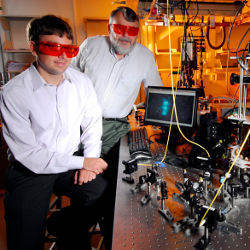 Two men wearing goggles in front of computing components